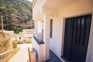 a door to a house with a mountain in the background at Appartamento Buggerru Blue Nest in Buggerru