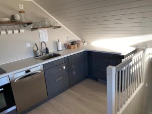 a kitchen with blue cabinets and a sink and a staircase at Apartment in beautiful Stange in Stange