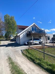 a house with a car parked next to a road at Apartment in beautiful Stange in Stange +6 photos