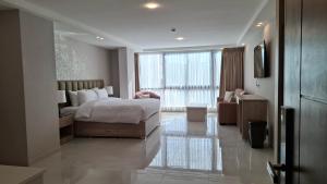 ein Schlafzimmer mit einem Bett und einem großen Fenster in der Unterkunft فندق جواهر العبدلي - Jawaher Hotel in Amman