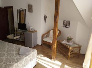 a room with a bed and a chair and a table at Family Hotel Bellehouse in Chernomorets