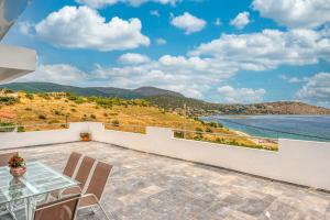 a balcony with a table and chairs and a view of the water at R&M Ocean View in Dhaskalión
