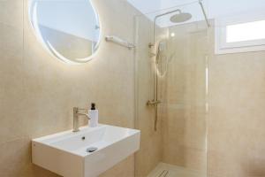 a bathroom with a sink and a shower with a mirror at R&M Ocean View in Dhaskalión +45 photos