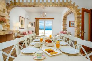 a dining room with a table with food on it at R&M Ocean View in Dhaskalión