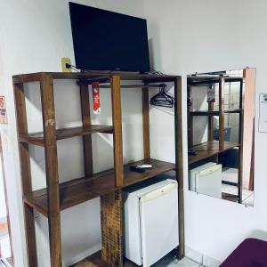 a book shelf with a tv on top of it at Pousada do Carlos in Arraial d'Ajuda