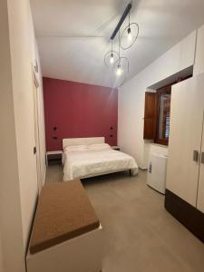 a bedroom with a bed and a red wall at B&b Al Castello in Gerace