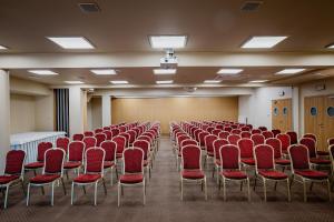an empty room with red chairs and a podium at Hotel Kahlberg in Krynica Morska +197 photos