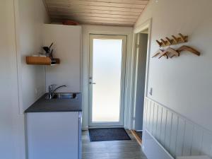 a kitchen with a sink and a door to a backdoor at BLÅBJERGGAARD - Hennebysvej 60 in Henne Strand