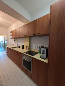 a kitchen with wooden cabinets and a stove top oven at Maison de Florence in Brussels