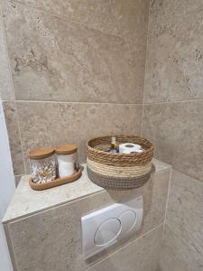 a bathroom with two baskets on a stone wall at Studio cosy devant RER B TGV Massy SNCF in Massy +6 photos