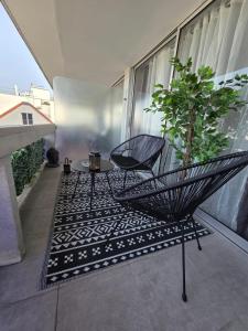 a black chair and a table on a balcony at Studio cosy devant RER B TGV Massy SNCF in Massy