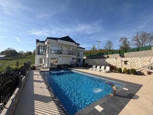 a house with a swimming pool in front of a house at Villa Berisha in Mazgit
