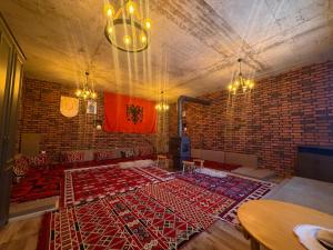 a room with a brick wall and a red rug at Villa Berisha in Mazgit +20 photos
