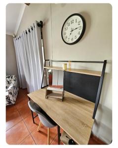 a clock on a wall above a wooden table at StayAtGoethe in Secunda +7 photos
