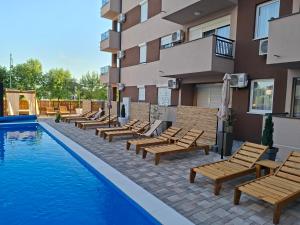 a hotel with a pool with lounge chairs next to a building at Silver 2 & SPA in Veliko Gradište