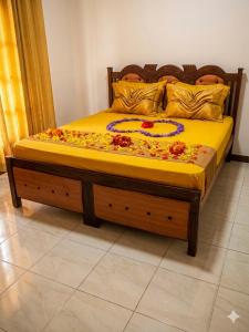 a bed with a wooden frame with flowers on it at The White Grand Heritage in Balangoda