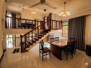 a dining room with a table and a staircase at The White Grand Heritage in Balangoda +2 photos