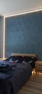 ein Schlafzimmer mit einem Bett und einer blauen Wand in der Unterkunft Michael Apartment in Valga