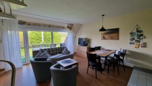 a living room with a couch and a table at Boddenhof Apartment 52 - Balkon, hundefreundlich in Buschvitz