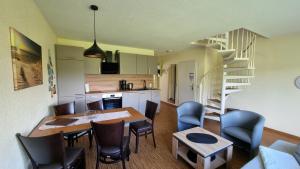 a kitchen and dining room with a table and chairs at Boddenhof Apartment 52 - Balkon, hundefreundlich in Buschvitz