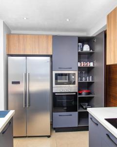 a kitchen with a stainless steel refrigerator and a microwave at Solaris Luxury Residence Osu Pool Gym in Accra