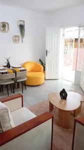 a living room with a table and a yellow chair at Côté Plage Kribi Studio Soleil in Kribi