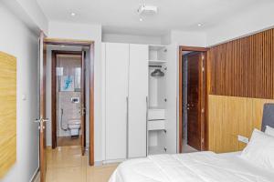 a bedroom with a bed and a bathroom with a toilet at Solaris Luxury Residence Osu Pool Gym in Accra +11 photos
