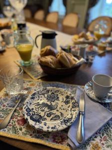 a table with a plate of food and a bowl of bread at Château La Rametière in Le PARC