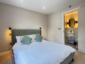 a bedroom with a large bed with blue pillows at Stylish City Centre Flat - Walk to Trinity & Station in Leeds