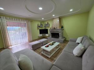 a living room with a couch and a fireplace at N'Gegaj Villa in Shkodër