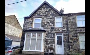 a stone house with white doors and windows at Anghorfa in Llanberis