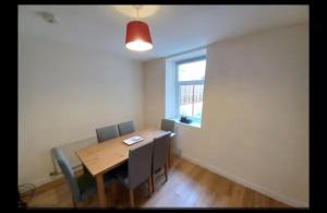 a dining room with a table and chairs and a window at Anghorfa in Llanberis +3 photos
