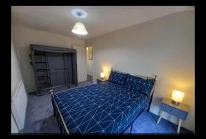 a bedroom with a bed with a blue comforter at Anghorfa in Llanberis