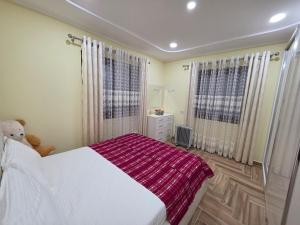 a bedroom with a white bed and a teddy bear at N'Gegaj Villa in Shkodër