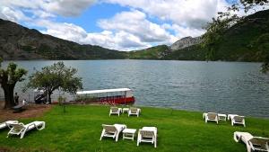 a group of chairs sitting on the grass near a lake at N'Gegaj Villa in Shkodër