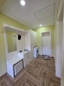 a kitchen with white cabinets and a wooden floor at N'Gegaj Villa in Shkodër +6 photos