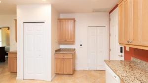 a kitchen with two white doors and a counter at Spacious One-Bedroom Condo with Pool View, Balcony & Beach Club Access in Coco