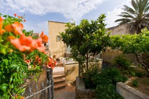 einen Garten mit Orangenblüten und einem Zaun in der Unterkunft History Hotel in Valderice