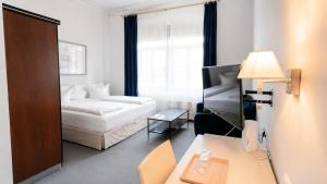 pokój hotelowy z łóżkiem, biurkiem i stołem w obiekcie Saigon Blue Hotel w Dreźnie