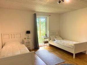 two beds in a room with a window at Villa Bergsmåla in Eringsboda