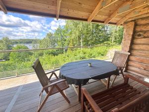 a wooden porch with a table and chairs on a deck at Villa Bergsmåla in Eringsboda