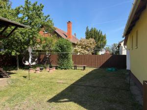 a yard with a bench and a fence at Harmat Apartman Hajdúnánás in Hajdúnánás