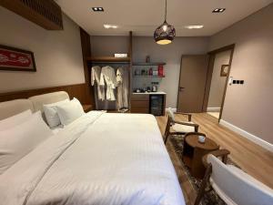a bedroom with a large white bed and a kitchen at Atrah Quiet Stylish Studio in Medina +5 photos