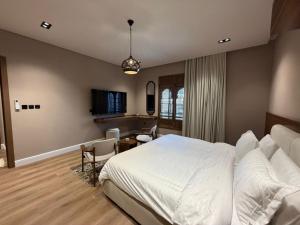 a bedroom with a large white bed and a desk at Atrah Quiet Stylish Studio in Medina