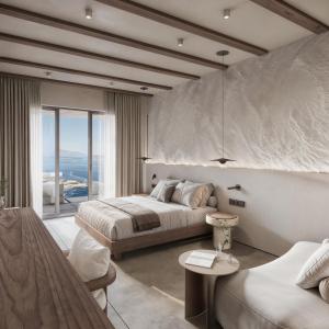 a bedroom with a bed and a large window at Geomilos Private Suites Milos in Triovasálos