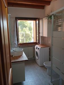 a bathroom with a sink and a washing machine at Casa LB14 in Castelletto Borgo