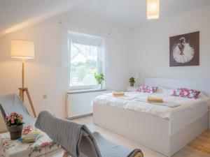 a white bedroom with a bed and a table and chairs at Apartments Bukor with seasonal pool in Lukovica pri Domžalah