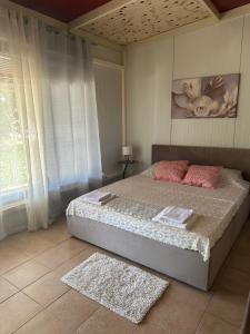 a bedroom with a large bed with pink pillows at IGI Apartments in Bogorodica