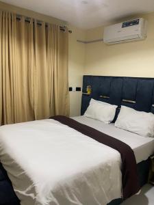 a bedroom with a large bed with a blue headboard at Chase hotels in Ibadan