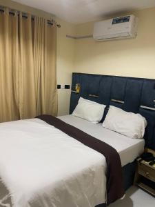 a bedroom with a large bed with a blue headboard at Chase hotels in Ibadan